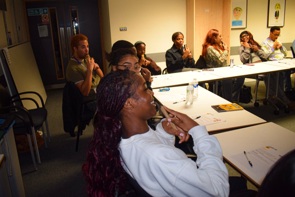 Participants engaged in an Igbo Flute Workshop at University College London, learning about the Oja flute and practicing playing it.