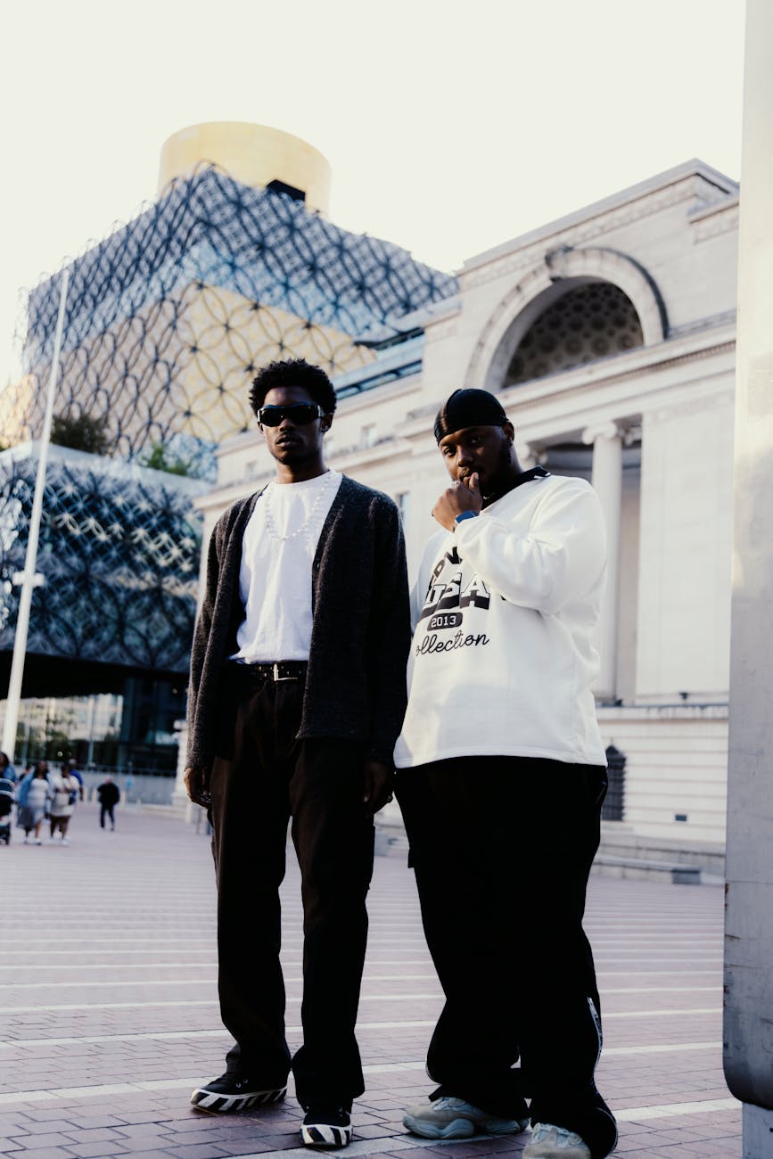 two young men standing in a public square near library of birmingham england